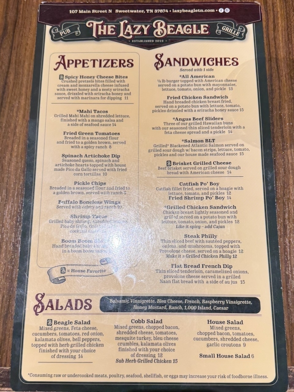 Auto-generated description: A menu from The Lazy Beagle Pub & Grill features a variety of appetizers, sandwiches, and salads with detailed descriptions of each dish.